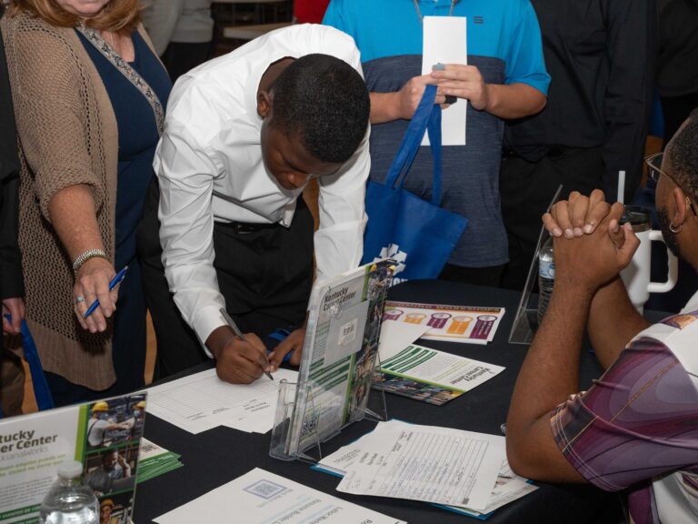 Young man completing a job application at the 2025 Coalition Forward Job Fair